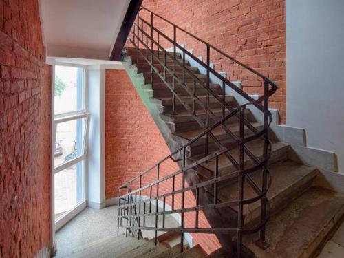 a spiral staircase in a brick building with a window at Najtańsze noclegi in Łódź