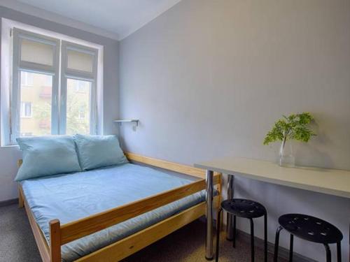 a bedroom with a bed with a counter and stools at Najtańsze noclegi in Łódź