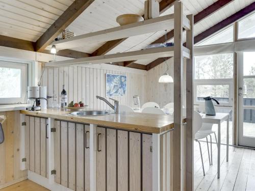 a kitchen with wooden walls and a counter with a sink at Holiday Home Eliana - 350m from the sea in NE Jutland by Interhome in Strandby