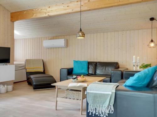 uma sala de estar com um sofá e uma mesa em Holiday Home Arny - 1-5km from the sea in NE Jutland by Interhome em Ålbæk