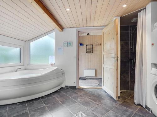 uma casa de banho com uma banheira, um chuveiro e um lavatório. em Holiday Home Arny - 1-5km from the sea in NE Jutland by Interhome em Ålbæk