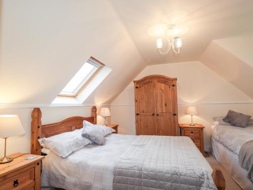 a attic bedroom with two beds and a window at The Mouries in Fochabers