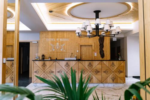 a lobby with a reception desk and a chandelier at Hotel Maria & Spa in Szczawnica