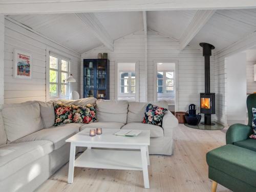 een woonkamer met een witte bank en een tafel bij Holiday Home Dorthea - 200m from the sea in NE Jutland by Interhome in Jerup