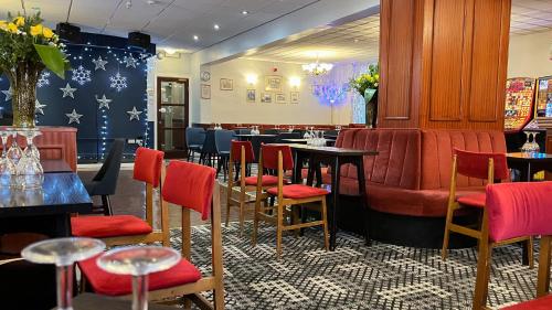 a restaurant with red chairs and tables in a room at Sutcliffe Hotel in Blackpool