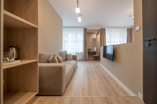 een woonkamer met een bank en een televisie bij Karoly Boutique Suites, Best Location by BQA in Boedapest