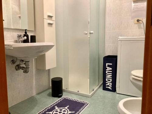 een badkamer met een wastafel, een toilet en een tapijt bij Terrazza a pochi passi dal mare in Loano