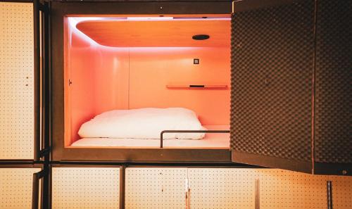 a small room with a bed inside of a cabinet at SLEEEP JP Fujinomiya in Fujinomiya