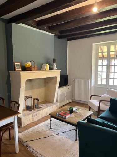 un salon avec une cheminée et un canapé dans l'établissement La maison de la tour, à Apremont