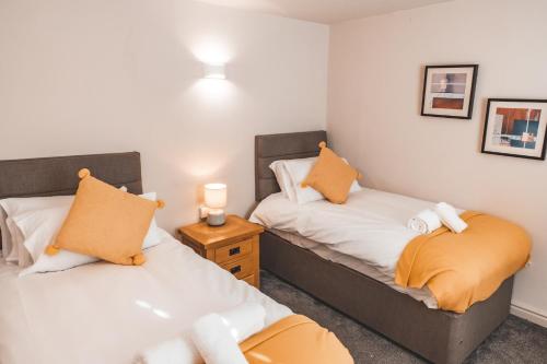 1 dormitorio con 2 camas y mesa con lámpara en Croppers Arms en Huddersfield