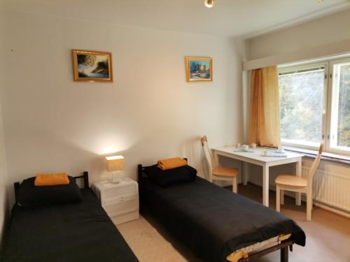 1 dormitorio con 2 camas, mesa y escritorio en Budget housing en Kouvola