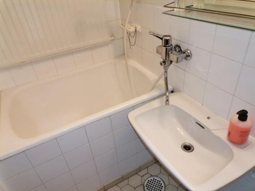 y baño blanco con lavabo y bañera. en Budget housing en Kouvola