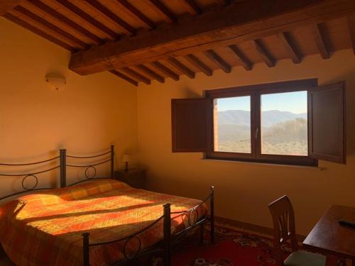 una camera con letto e finestra di La Locanda Del Colle a Canalicchio