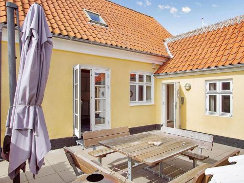 une terrasse avec une table en bois et un parasol dans l'établissement Holiday Home Minte - 450m from the sea in NW Jutland by Interhome, à Skagen