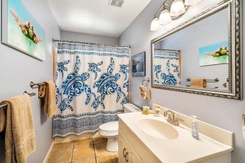 een badkamer met een wastafel, een toilet en een spiegel bij Honu O Kai turtle Of The Sea in Kailua-Kona