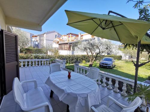 a table and chairs and an umbrella on a patio at Home Nicole in Bibinje