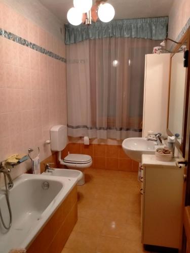 a bathroom with a tub and a toilet and a sink at Margherita in Boccon