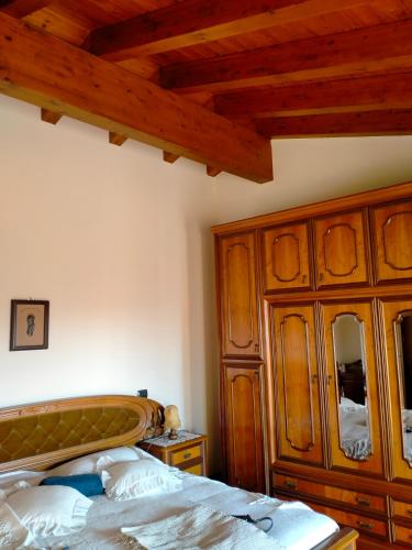 una camera con letto e armadio in legno di Margherita a Boccon