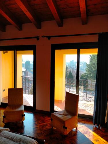 due sedie e un letto in una stanza con finestre di Margherita a Boccon