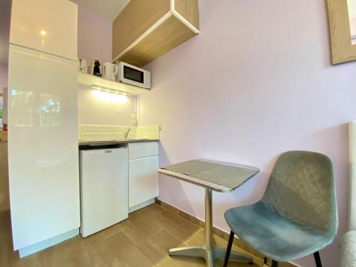 une petite cuisine avec une table et une chaise dans l'établissement Gallia Bella By SCLS Locations, à Cannes