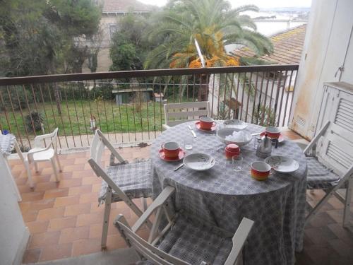 a table and chairs on a balcony with a view of a yard at Nunzia - Trilocale con terrazzo vista mare e doppi servizi in Sirolo