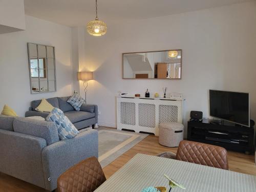 a living room with a couch and a tv at Stones Throw-near harbour & beach Pet Friendly in Weymouth