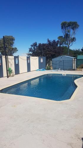 a swimming pool in a parking lot next to a fence at Wimmera Motel in Nhill