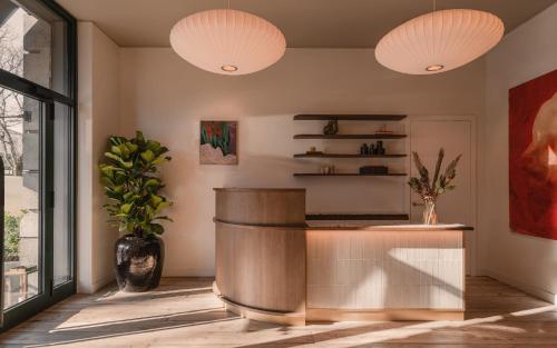 a lobby with two pendant lights and a counter at Aethos Milan in Milan