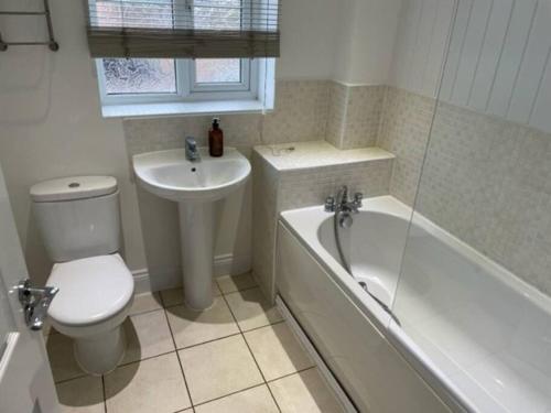 y baño con aseo, lavabo y bañera. en *BRAND NEW* renovated 3 bed with parking & WIFI en Corby