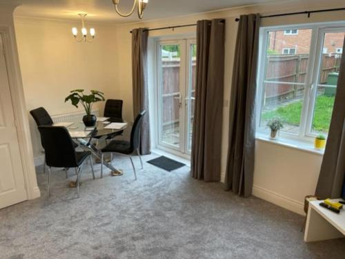 a room with a table and chairs and a window at *BRAND NEW* renovated 3 bed with parking & WIFI in Corby