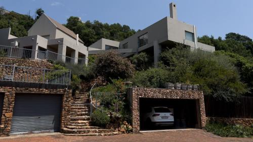 a house with a garage with a car in it at Orangerie Guest House in Johannesburg