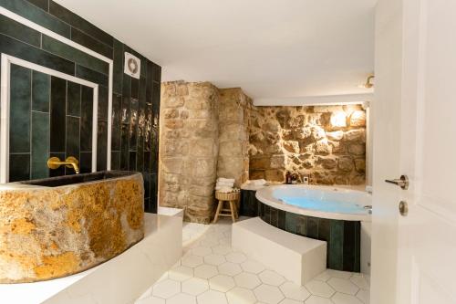 uma casa de banho com uma banheira grande e um lavatório em Santorini em Acre