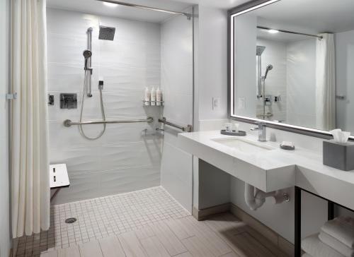 ein weißes Bad mit einem Waschbecken und einer Dusche in der Unterkunft Orlando World Center Marriott in Orlando