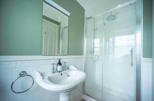 a white bathroom with a sink and a shower at Cross Keys Inn Ettrickbridge in Ettrickbridge End