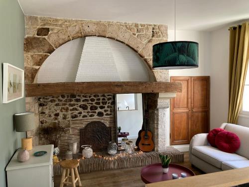 a living room with a stone fireplace with a guitar at Logis « Henriette » • Maison du XVe siècle in Provins