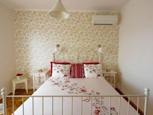 een slaapkamer met een wit bed met rode kussens bij Villa Antonija heated private pool, near Dubrovnik,8plus 2 p ideal for families and groups in Čilipi