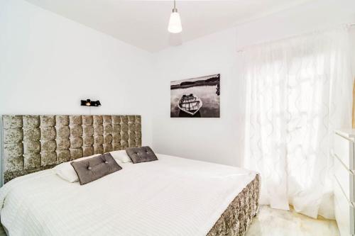 - une chambre avec un grand lit et des draps blancs dans l'établissement Luxurious apartment close to Puerto Banus, à Estepona