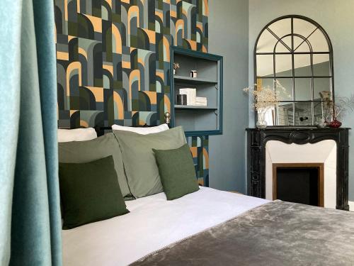 - une chambre avec un lit et un mur avec une cheminée dans l'établissement Logis « Henriette » • Maison du XVe siècle, à Provins