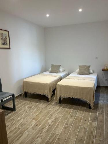 deux lits dans une chambre avec parquet dans l'établissement Maison de charme au bout du CAP CORSE, à Ersa