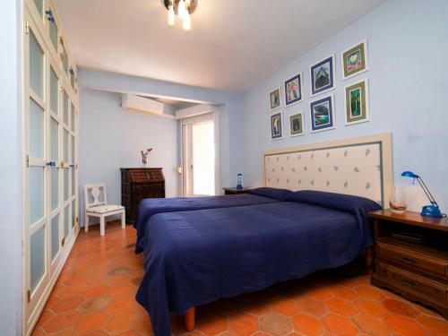 Schlafzimmer mit einem Bett mit blauer Tagesdecke in der Unterkunft Apartment Damara IV by Interhome in Calpe