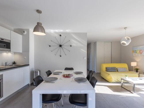 une cuisine et un salon avec une table et des chaises blanches dans l'établissement Apartment Les Cyprès by Interhome, à Saint-Malo