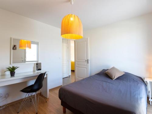 une chambre avec un lit, un bureau et une chaise dans l'établissement Apartment Les Cyprès by Interhome, à Saint-Malo
