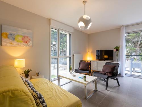 un salon avec un canapé jaune et une table dans l'établissement Apartment Les Cyprès by Interhome, à Saint-Malo