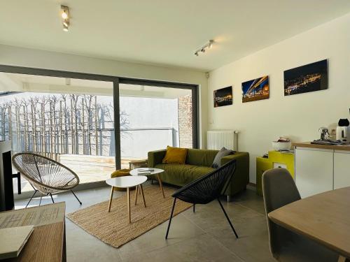 uma sala de estar com um sofá, uma mesa e cadeiras em Les Valcaprimontoises em Chaudfontaine