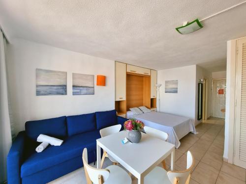 sala de estar con sofá azul y mesa en Apartamentos Eurhostal 3000, en Alcossebre