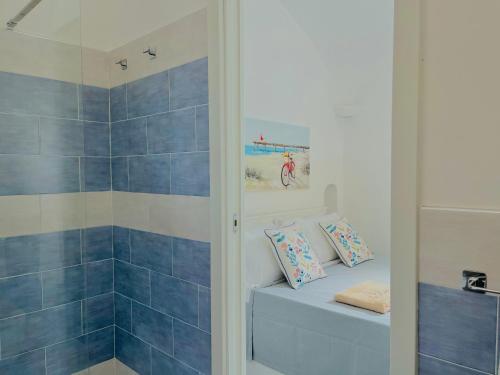 baño de azulejos azules con ducha y banco en La Dimora 4: Charm and Quiet, en SantʼAgata sui Due Golfi
