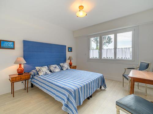 une chambre avec un lit bleu et une fenêtre dans l'établissement Apartment La Voilerie - La Brigantine by Interhome, à Carnac