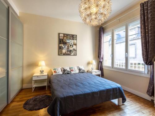 une chambre avec un lit et un lustre dans l'établissement Apartment Puits Aux Braies by Interhome, à Saint-Malo