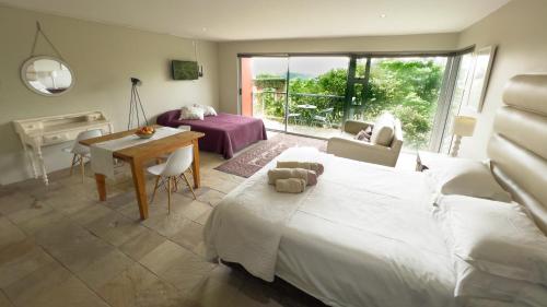 a bedroom with a bed and a table and a desk at Orangerie Guest House in Johannesburg