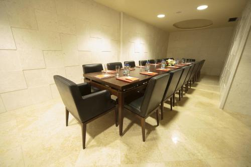 a long table in a room with black chairs at Mediteran Hotel & Resort in Budva
